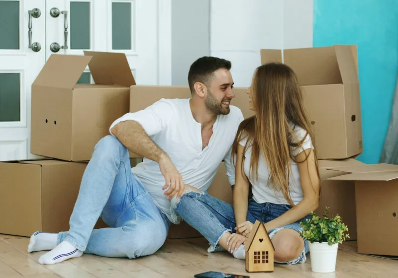 Couple sitting among packed moving boxes